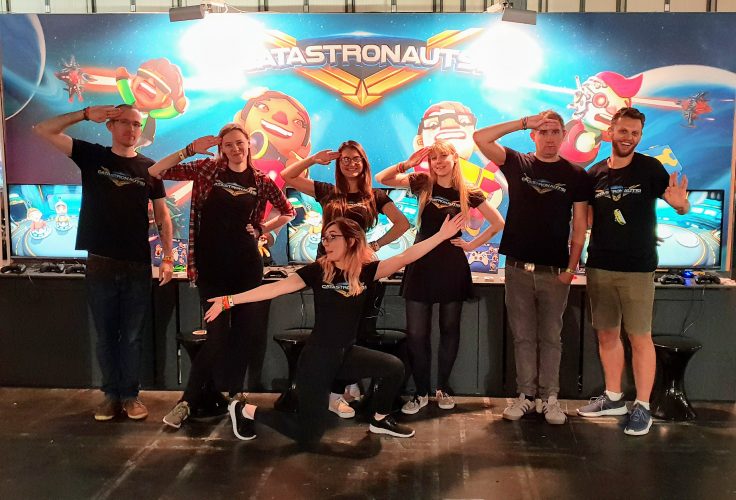 The group of us doing funny poses (mainly salutes) in front of our EGX stand, wearing Catastronauts t-shirts