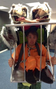 Graeme dressed as a two headed dinosaur carrying a cage with a convict in (yes, it's a very complicated costume)